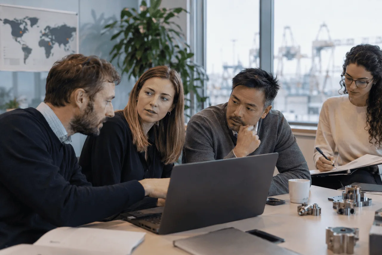 Professionals comparing technical information and industrial components during a sourcing discussion
